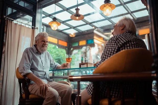 Man glimlachend terwijl het drinken van alcohol met vriend — Stockfoto