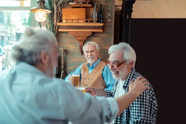 술집에서 맥주를 마시며 웃고 있는 연금수령자들 — 스톡 사진