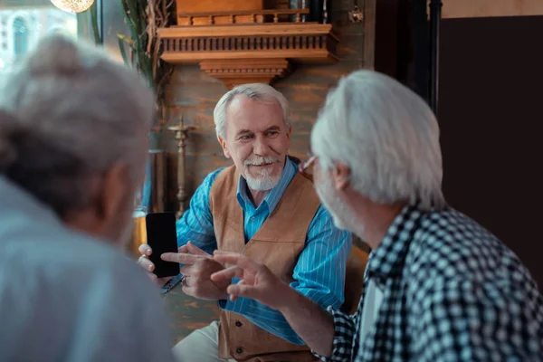 Hombre mostrando foto mientras bebe cerveza con amigos —  Fotos de Stock