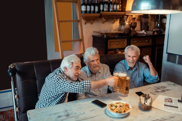 Důchodci oslavují vítězství oblíbeného fotbalového týmu — Stock fotografie