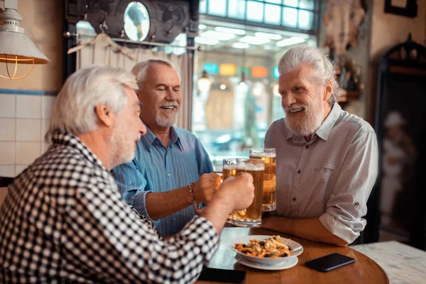 Позитивні пенсіонери стискають окуляри пивом — стокове фото