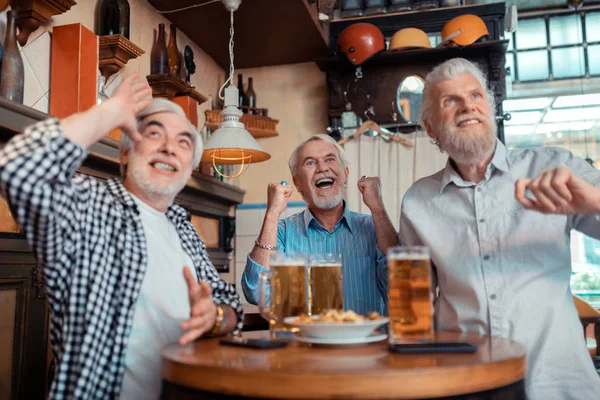 Tres pensionistas activos gritando mientras miran fútbol — Foto de Stock