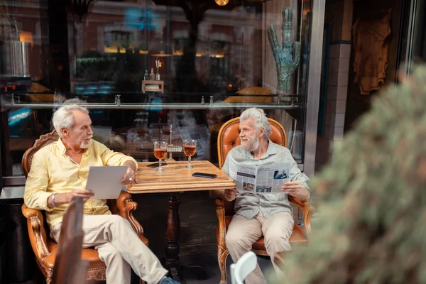 Emerytowany mężczyźni picia whisky i czytania wiadomości rano — Zdjęcie stockowe