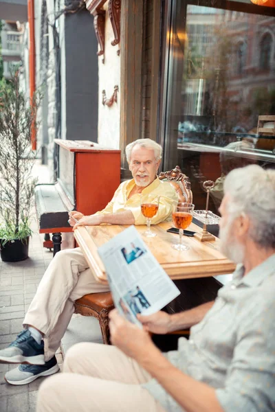 Spotkanie mężczyzn na weekend siedzący poza kawiarnią — Zdjęcie stockowe