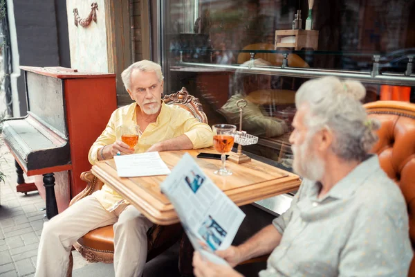 Grijs harige gepensioneerde mannen die gesprek buiten zitten — Stockfoto