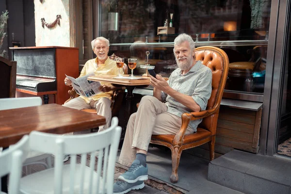 Hombres jubilados leyendo noticias y disfrutando del tiempo afuera —  Fotos de Stock