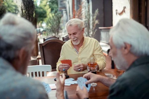 Uomo barbuto che indossa anelli gioco d'azzardo con gli amici — Foto Stock