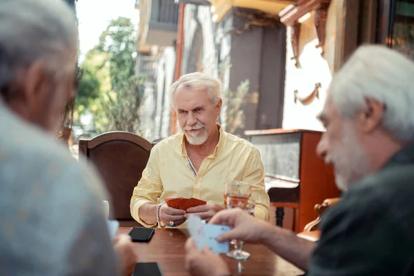 Serious barbudo anciano juego con amigos — Foto de Stock