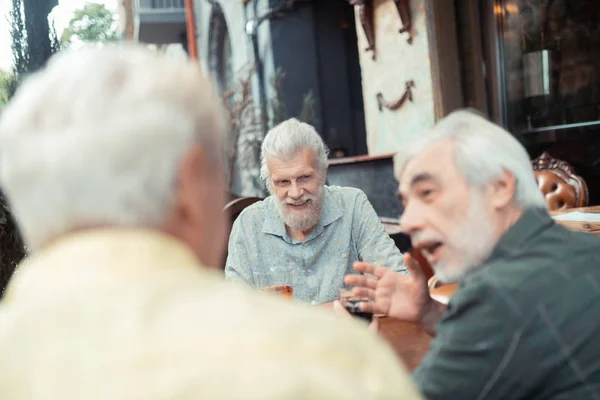 Emerytowany mężczyzna rozmawia i pije alkohol na zewnątrz — Zdjęcie stockowe