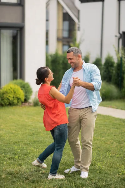 Marido bailando con su esposa y sonriendo mientras se siente feliz — Foto de Stock