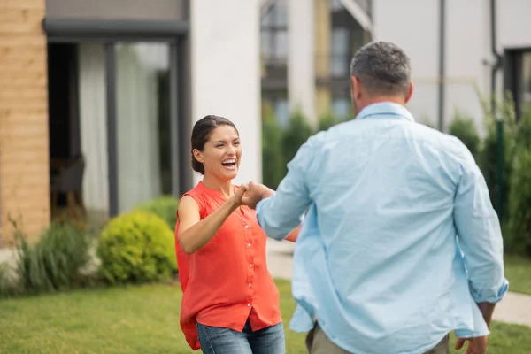 Esposa riendo mientras baila con el marido cerca de casa — Foto de Stock
