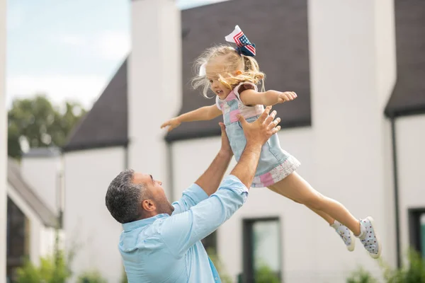 Daughter flying in the air while having fun with her daddy — Stock Photo, Image