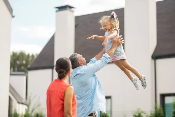 Hija encantadora sintiéndose increíble mientras padre la levanta — Foto de Stock