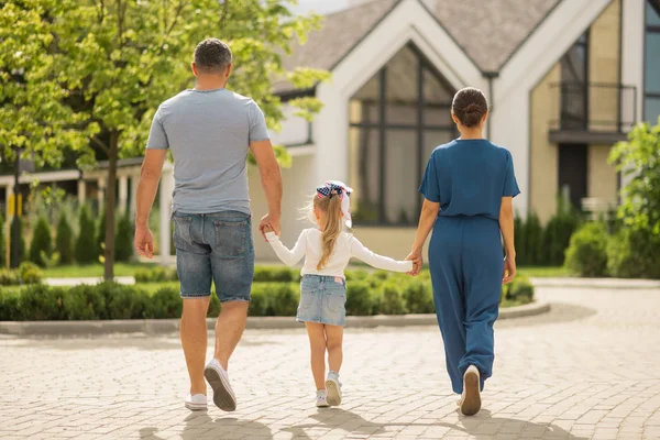 Couple of businessmen walking with their little girl in the town — Stock Photo, Image