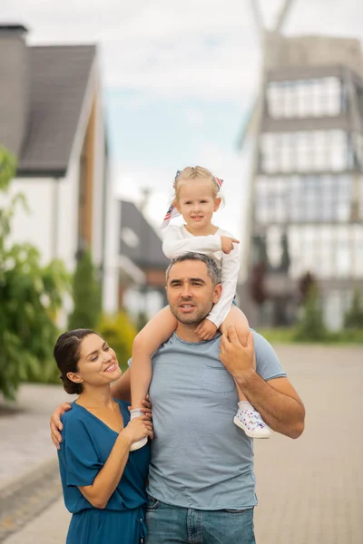 Father with daughter on neck walking with wife and his girl — Stock Photo, Image
