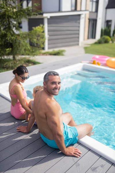 Radiante sensación de familia relajada mientras se enfría cerca de la piscina — Foto de Stock