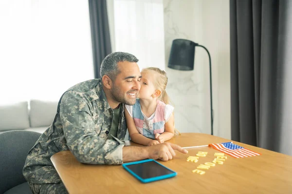 Daughter kissing father coming home after military service — Stock Photo, Image