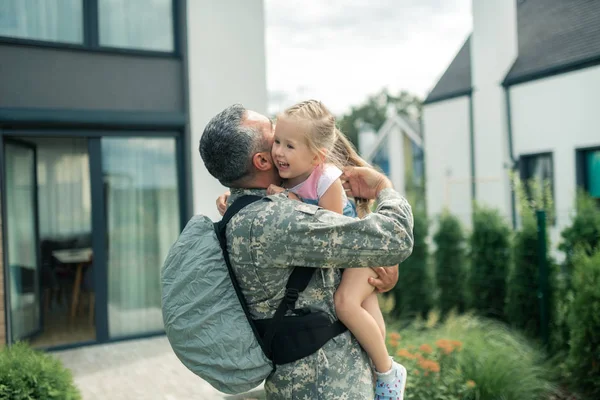 Military officer wearing uniform hugging his tender daughter — Stock Photo, Image