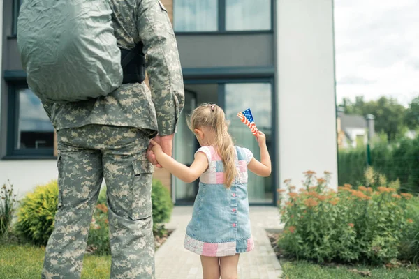 Schattig meisje Holding hand van haar vader dienen in strijdkrachten — Stockfoto