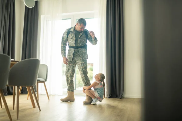 Serviceman kalmeren zijn dochter naar beneden terwijl terugkomen snel terug — Stockfoto