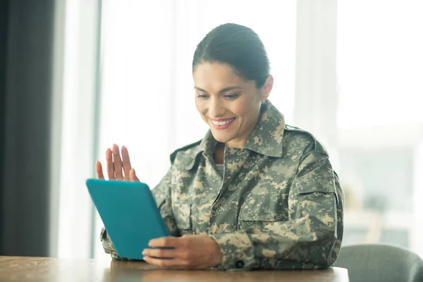 Woman serving in armed forces having video chat with family