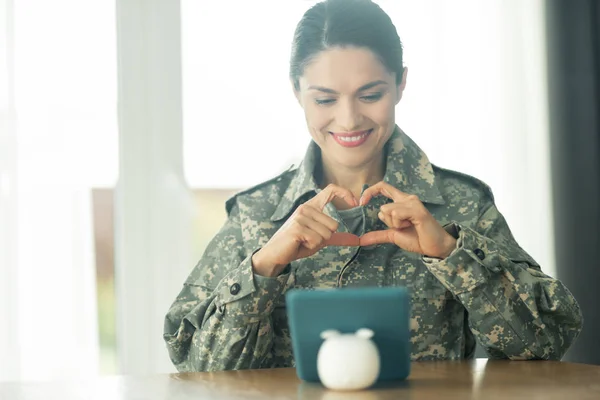 Красива військова жінка посміхається, показуючи всю свою любов до сім'ї — стокове фото