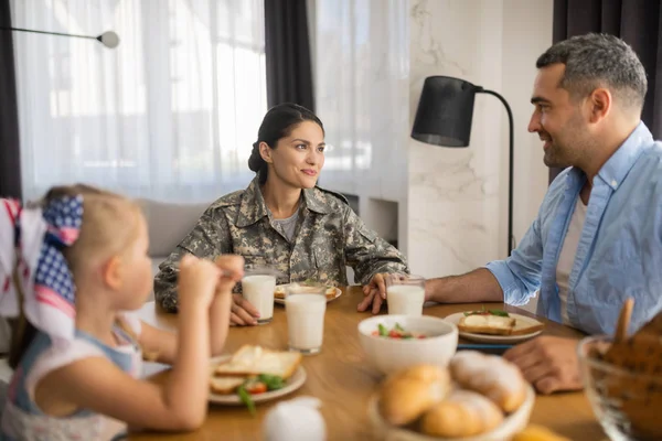 Beautiful female soldier spending morning with husband and daughter