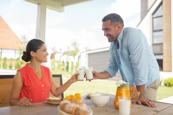 Pareja bebiendo leche por la mañana desayunando afuera — Foto de Stock