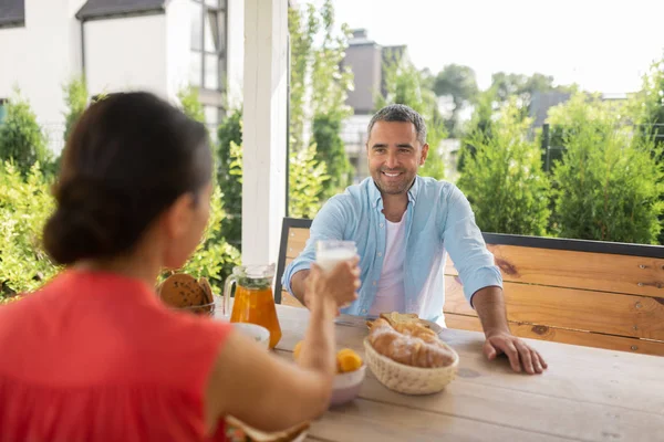 Чоловік посміхається під час сніданку зовні з дружиною — стокове фото