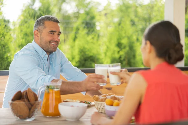 Couple drinking milk while enjoying breakfast outside — Stock Photo, Image