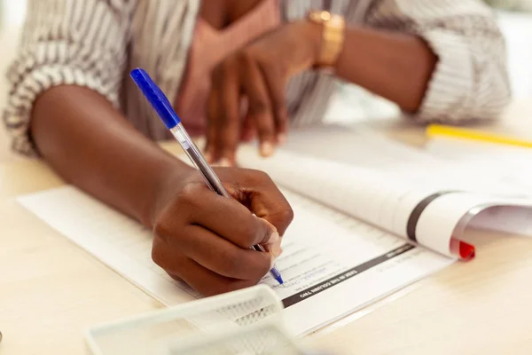 Inteligente persona femenina internacional completando la tarea gramatical —  Fotos de Stock