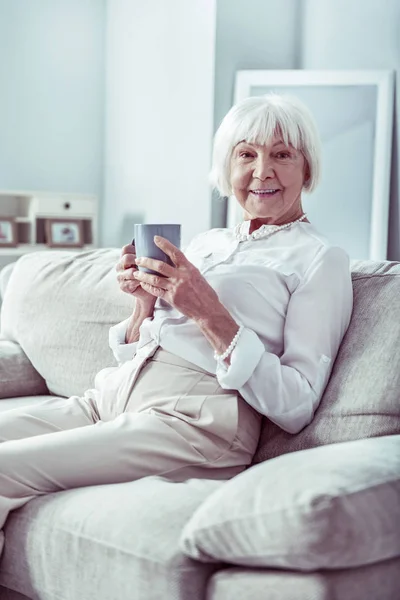 Beaming emerytowana kobieta uczucie ulgę podczas spędzania dnia w domu — Zdjęcie stockowe