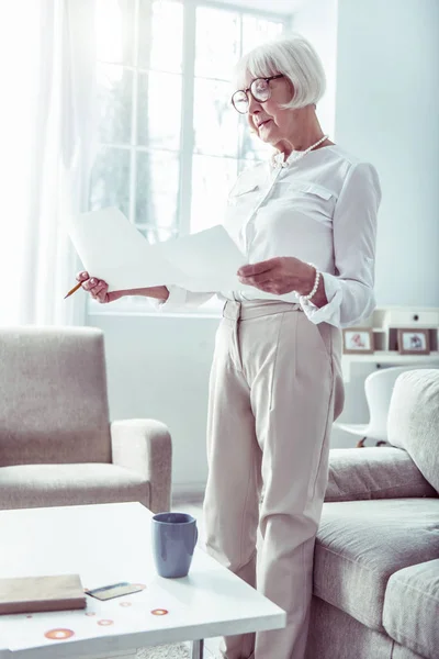 Mujer jubilada hermosa delgada usando pantalones beige haciendo negocios familiares — Foto de Stock