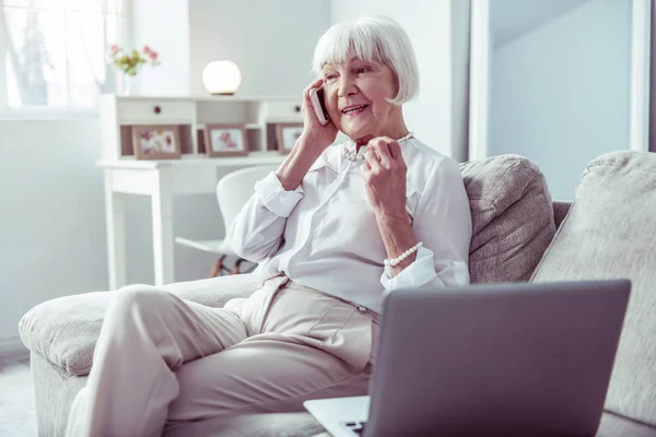 Trabajar mujer jubilada llamando a su socio de negocios sentado cerca del ordenador portátil — Foto de Stock