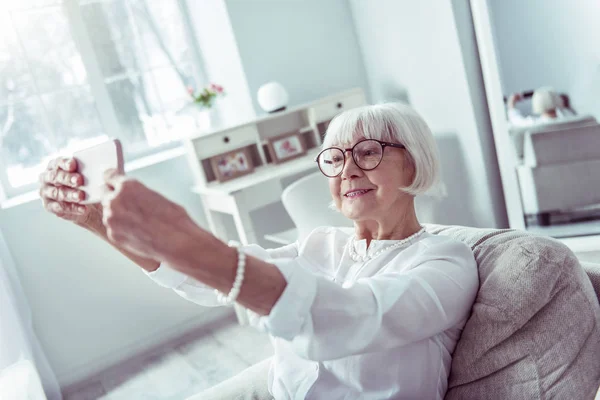 Selfie yaparken akıllı telefonunu tutan modern ışınlama yaşlı bayan — Stok fotoğraf