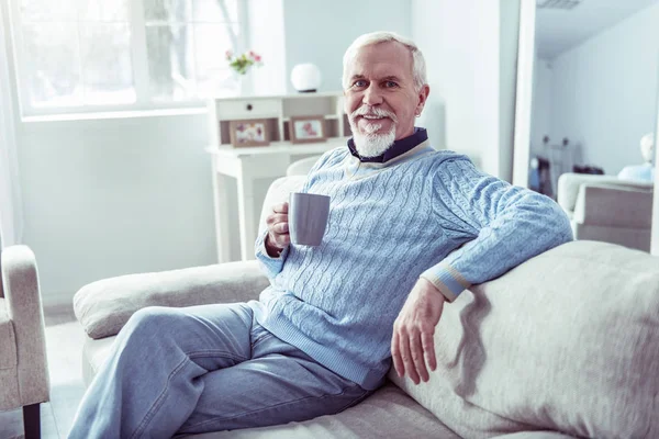 A modern nyugdíjas ember, némi pihenés otthon iszik csésze teát — Stock Fotó