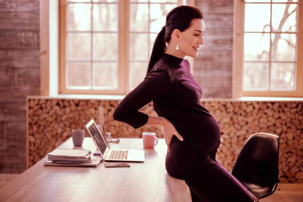 テーブルの上に座って肯定的な喜んだ妊娠 — ストック写真