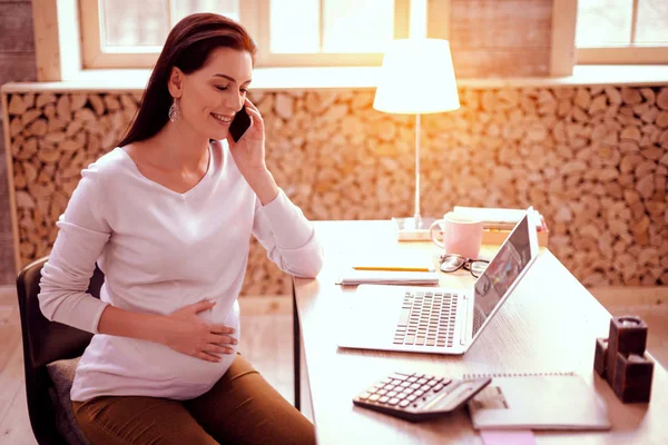 かなり妊娠中の若い女性が電話ごとに話す — ストック写真