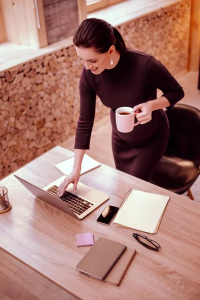 Persona femenina encantada positiva de pie en su lugar de trabajo — Foto de Stock