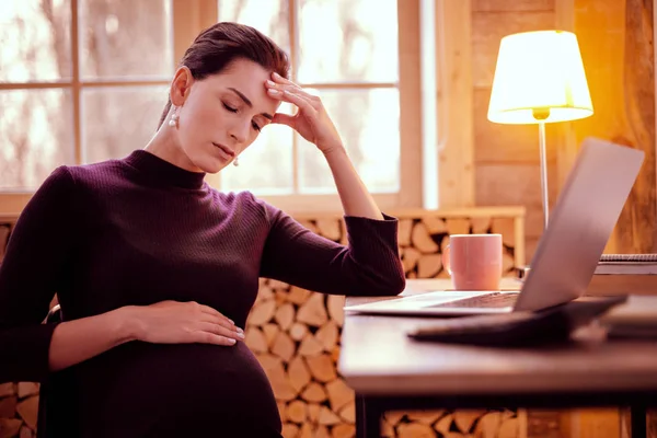 Upset brunette female caressing her baby bump — Stock Photo, Image