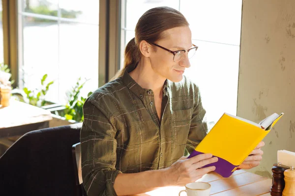 Hobby Hombre Agradable Positivo Sonriendo Mientras Lee Libro Favorito — Foto de Stock