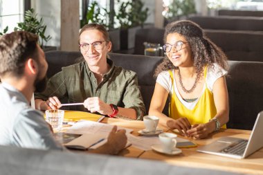 Olumlu neşeli arkadaşlar kendi başlangıç fikirlerini tartışıyor