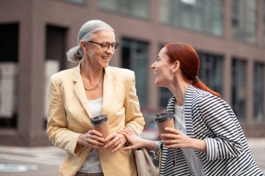 İyi arkadaşlar. Genç iş kadını onu memnun üst düzey arkadaşı onu açık havada yanında duran bakarken gülüyor