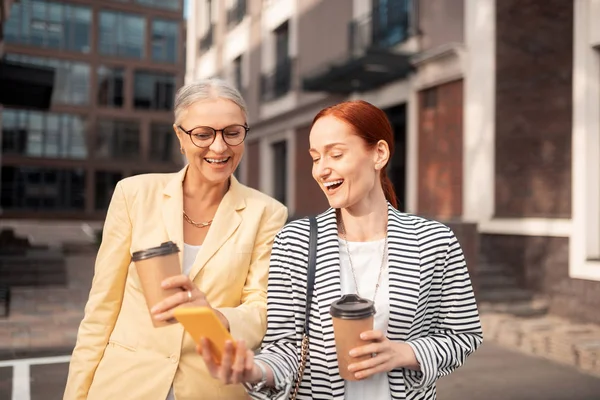 Gran Día Dos Mujeres Negocios Riendo Mirando Fotos Teléfono Inteligente — Foto de Stock