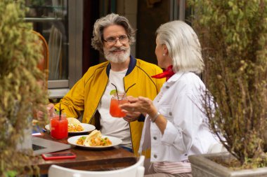 Güzel karısıyla yemek yeen adam.