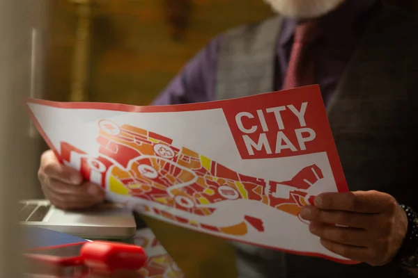 Bright city map in hands of a cafe visitor.