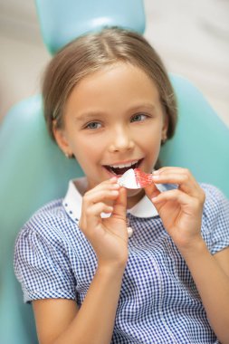 Ağız koruyucusu koyarken gülümseyen kontrol elbise giyen kız