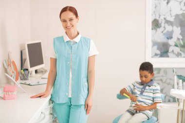 Oğlu iş yerinde onu ziyaret ederken çocuk diş hekimi gülümseyen