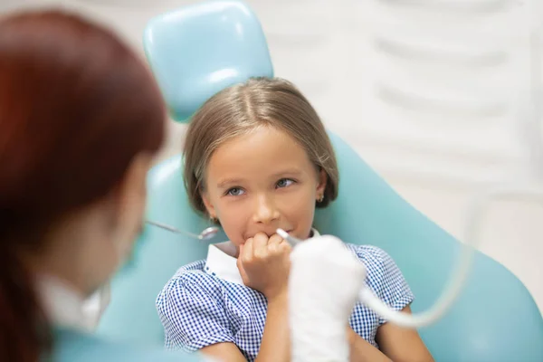 Linda chica cerrando la boca mientras visita al dentista — Foto de Stock