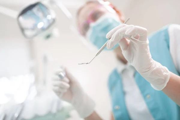 Close up of dentist wearing uniform holding dental equipment — Stock Photo, Image